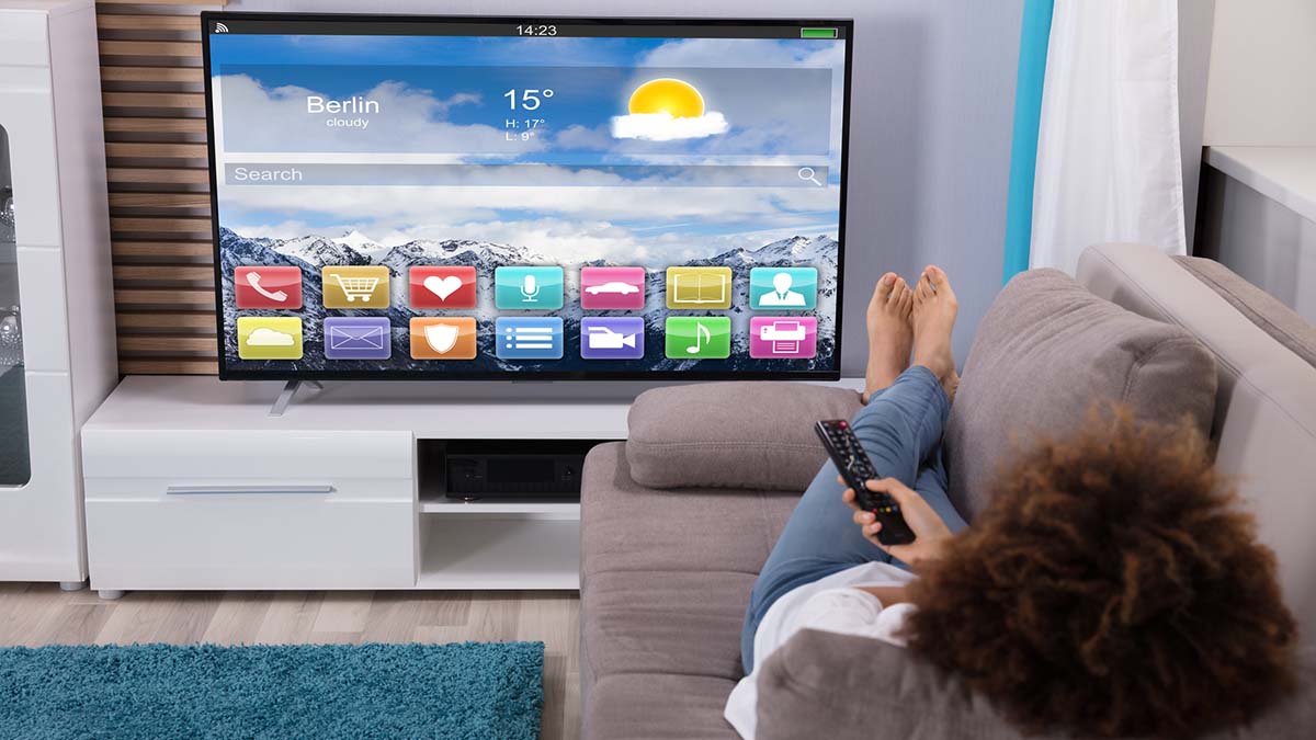 Mujer ve contenidos en la Connected TV desde su sofá