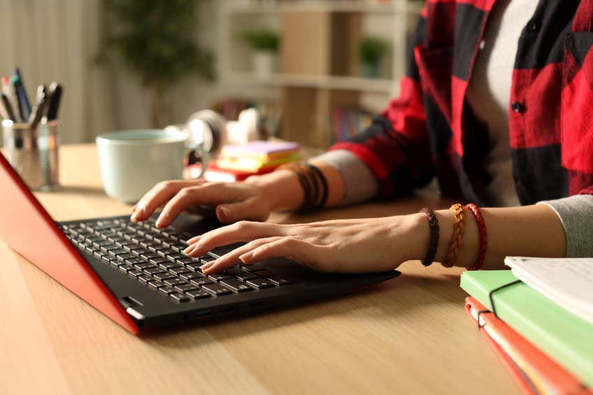 Una joven busca información en Internet con su ordenador portátil
