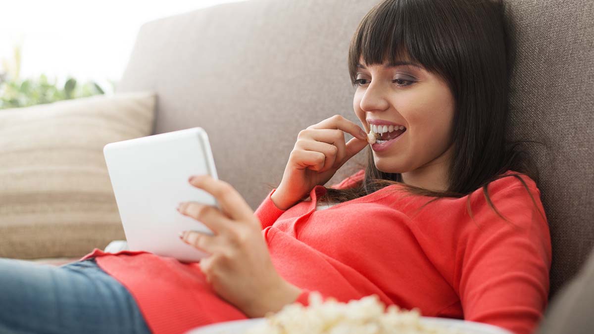 Una mujer consume contenido de vídeo online de plataformas de streaming en su tablet