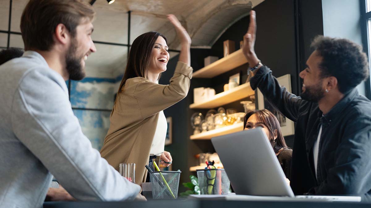 Profesionales chocan las manos en señal de alegría en una reunión de trabajo
