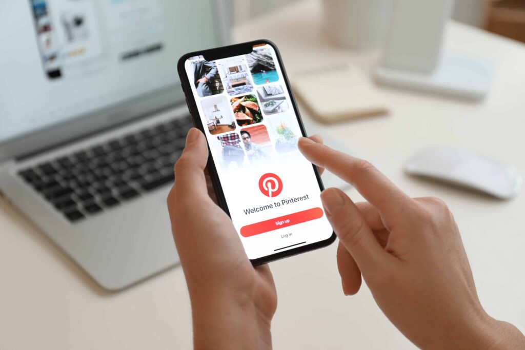 iPhone 11 with Pinterest app on screen at table, closeup